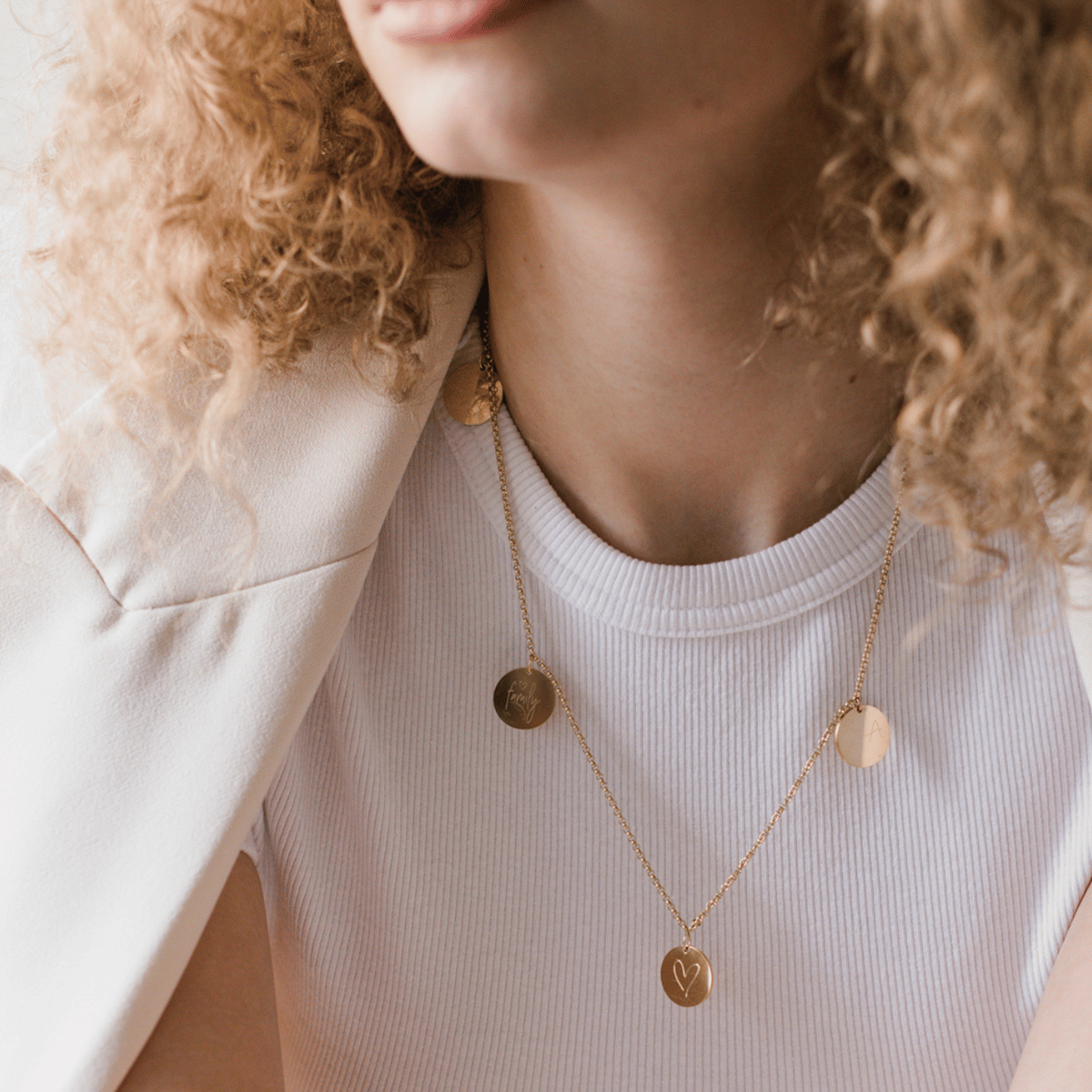 Mama trägt eine personalisierte famiilienkette in gold graviert mit den namen ihrer kinder, mit baby fussabdruck und initialen der familie. wundervolle geschenk für mütter zur geburt und zum muttertag