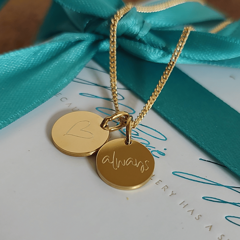 Detailansicht unserer Initialen kette gold mit 2 Gravur Plättchen individuell graviert mit Kindernamen, Baby Fussabdrücken und persönlichen Botschaften. Perfektes Geschenk für die Mama oder Oma, um ihre liebsten zu verewigen und stolz nah am Herzen tragen zu können