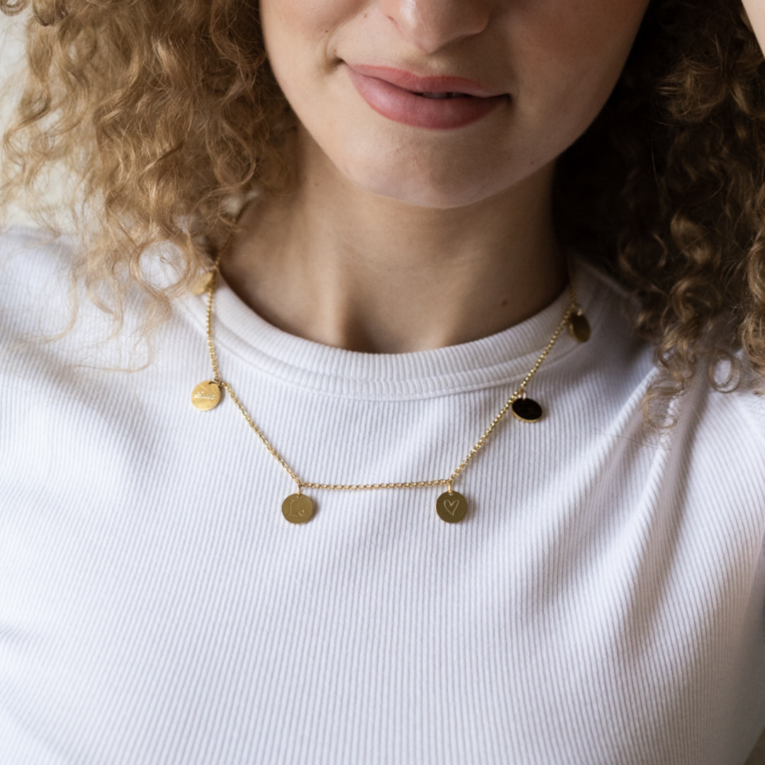 Goldkette mit fünf Gravur-Plättchen in 333 und 585 Gold - getragen am Hals der frischgebackenen mama - individuell für dich in unserer Berliner Goldschmiede angefertigt. Ein bedeutungsvolles und wertvolles geschenk für mütter und oma zu meilensteinen im leben, wie die geburt oder ein hochzeitstag