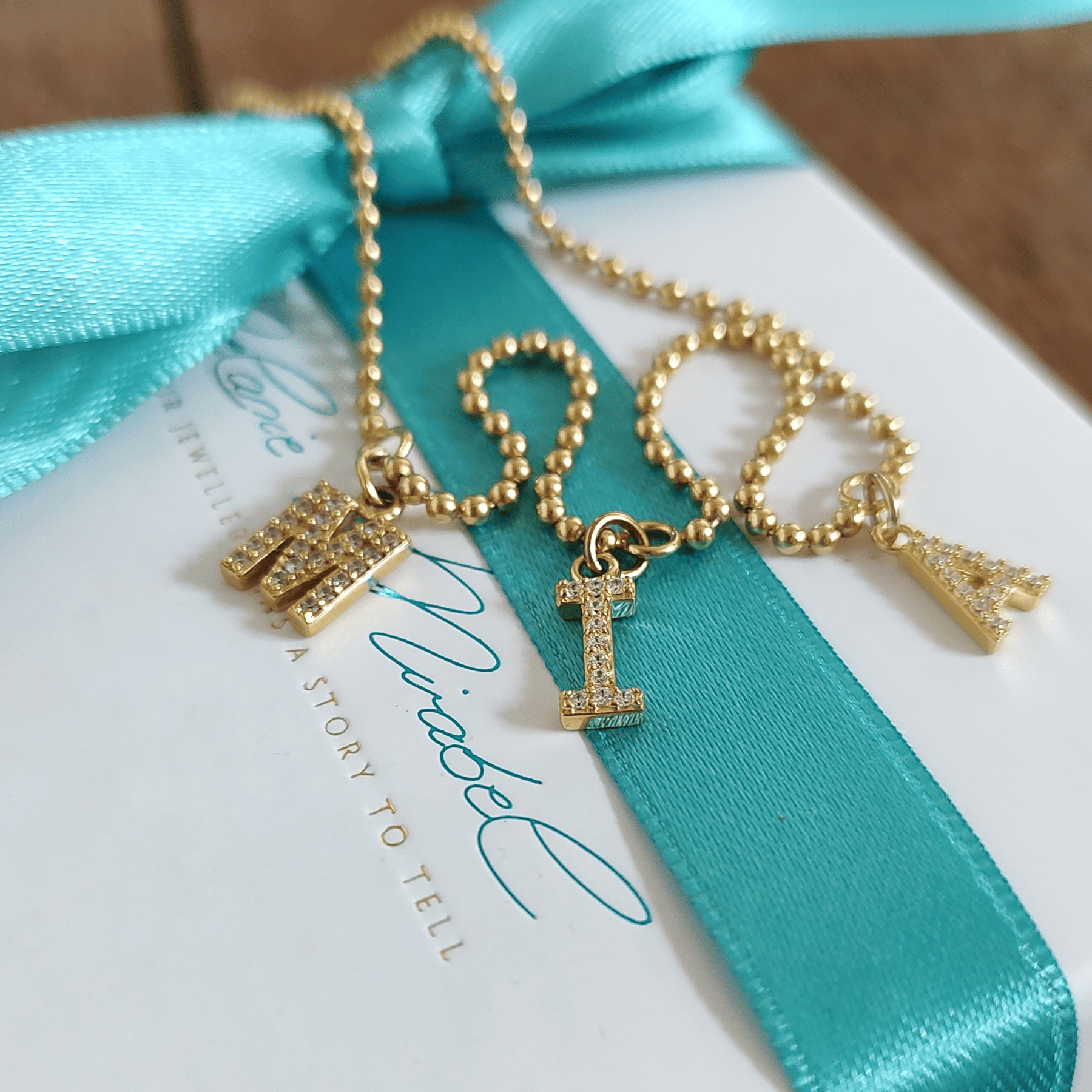 Goldkette mit drei Initialen, fein mit Zirkonia-Steinchen besetzt – individuell in unserem Berliner Studio gefertigt. Mit dieser Goldkette mit Buchstaben trägst Du ihr die Initialen der Kinder direkt am Herz. Drei zierliche Buchstabenanhänger, mit funkelnden Zirkoniasteinchen besetzt, in liebevoller Handarbeit in unserem Berliner Studio gefertigt – in 925 Sterlingsilber, 18K Vergoldung oder echtem 333 Gelbgold.