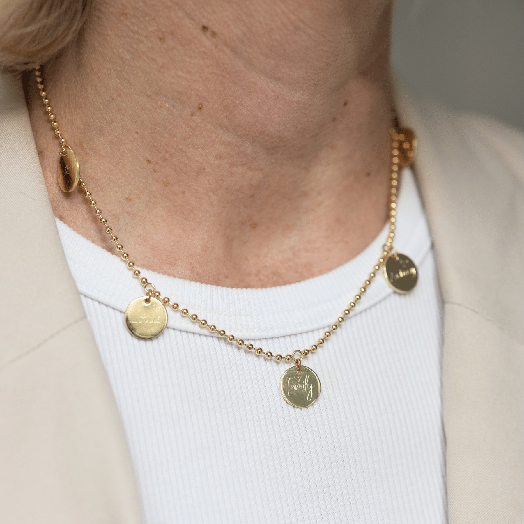 Die CREW LOVE Familienkette in 585 Echtgold mit fünf großen Gravur-Anhängern, am Hals getragen, ist elegant und zeitlos im Stil. die Gold Plättchen sind beidseitig gravierbar mit Namen der Kinder, Babyfussabdrücken, Handabdrücken, Handschriften der KInder  und werden so zu einem perfekten Geschenk für die Mama und auch Oma, um ihre Kinder und Enkelkinder immer bei sich tragen zu können