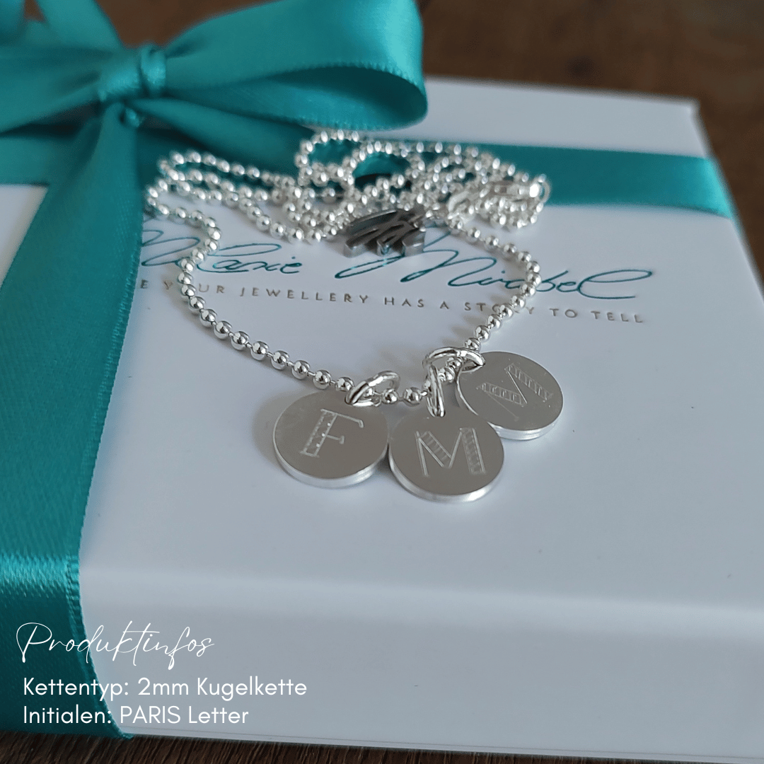 Detailsansicht personalisierte Plättchenkette als Geschenk von den Enkelkindern an die Oma, graviert mit ihren Anfangsbuchstaben und Namen. Ein liebevolles Andenken, das die Verbindung der Generationen sichtbar macht. Erhältlich in 925 Silber und vergoldetem Silber.