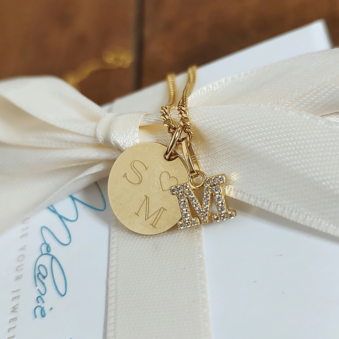 Goldkette mit dem Buchstaben M und einem Gravur-Plättchen. Wir gestalten Deine Buchstaben Kette Gold ganz nach Deinen Wünschen: mit dem Initialen Deiner Herzensmenschen, einem Datum oder einem persönlichen Symbol. 