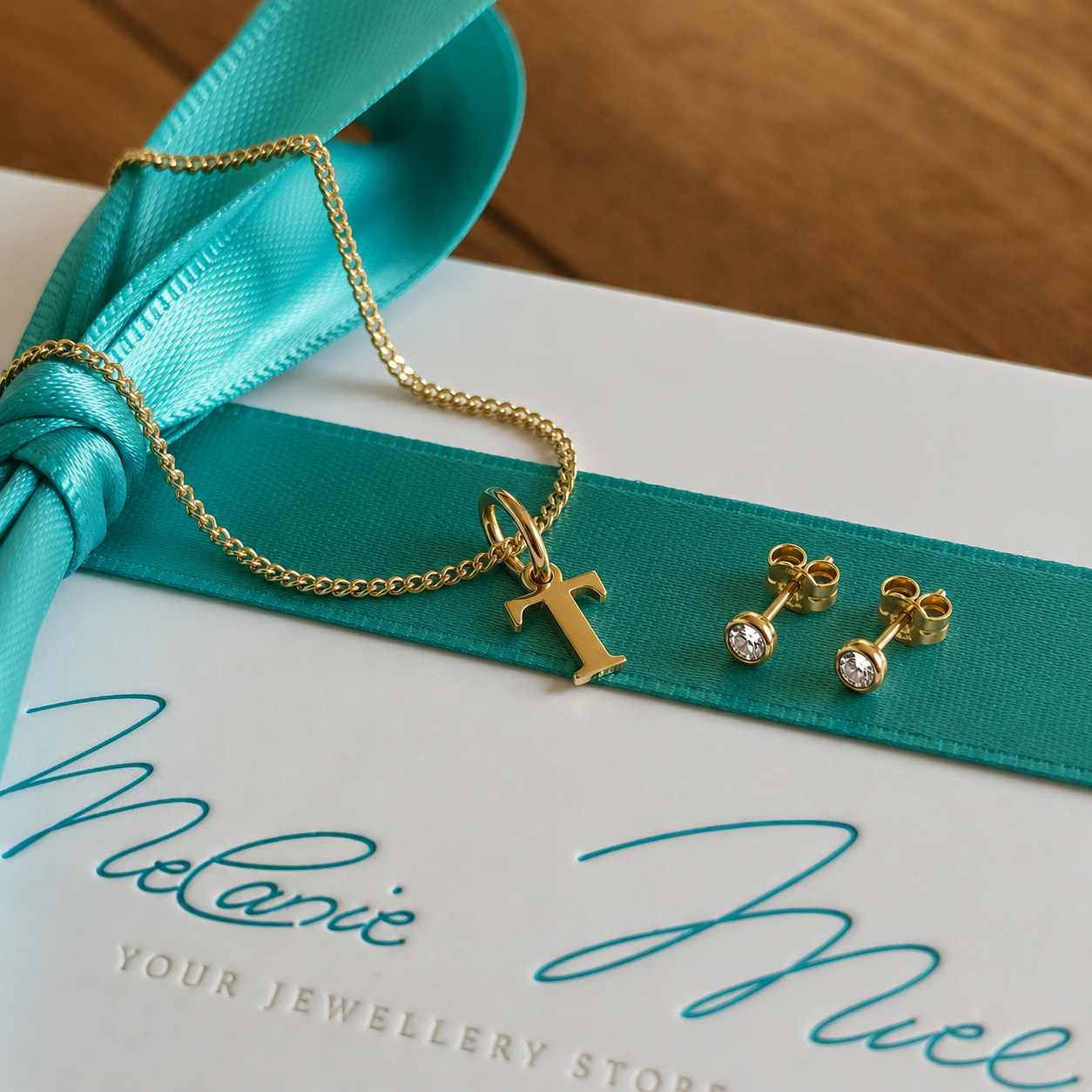Das GINA Geschenkset kombiniert die Goldkette mit dem Buchstaben T mit passenden Ohrsteckern – edel und aufeinander abgestimmt. Du suchst ein Geschenk für deine Freundin oder Ehefrau zum Valentinstag oder Jahrestag? Das wunderschöne Set mit der Goldkette mit ihrem Anfangsbuchstaben und den passenden Ohrsteckern ist ein tolles Geschenk. So trägt sie eure liebe jeden Tag nah am Herzen.