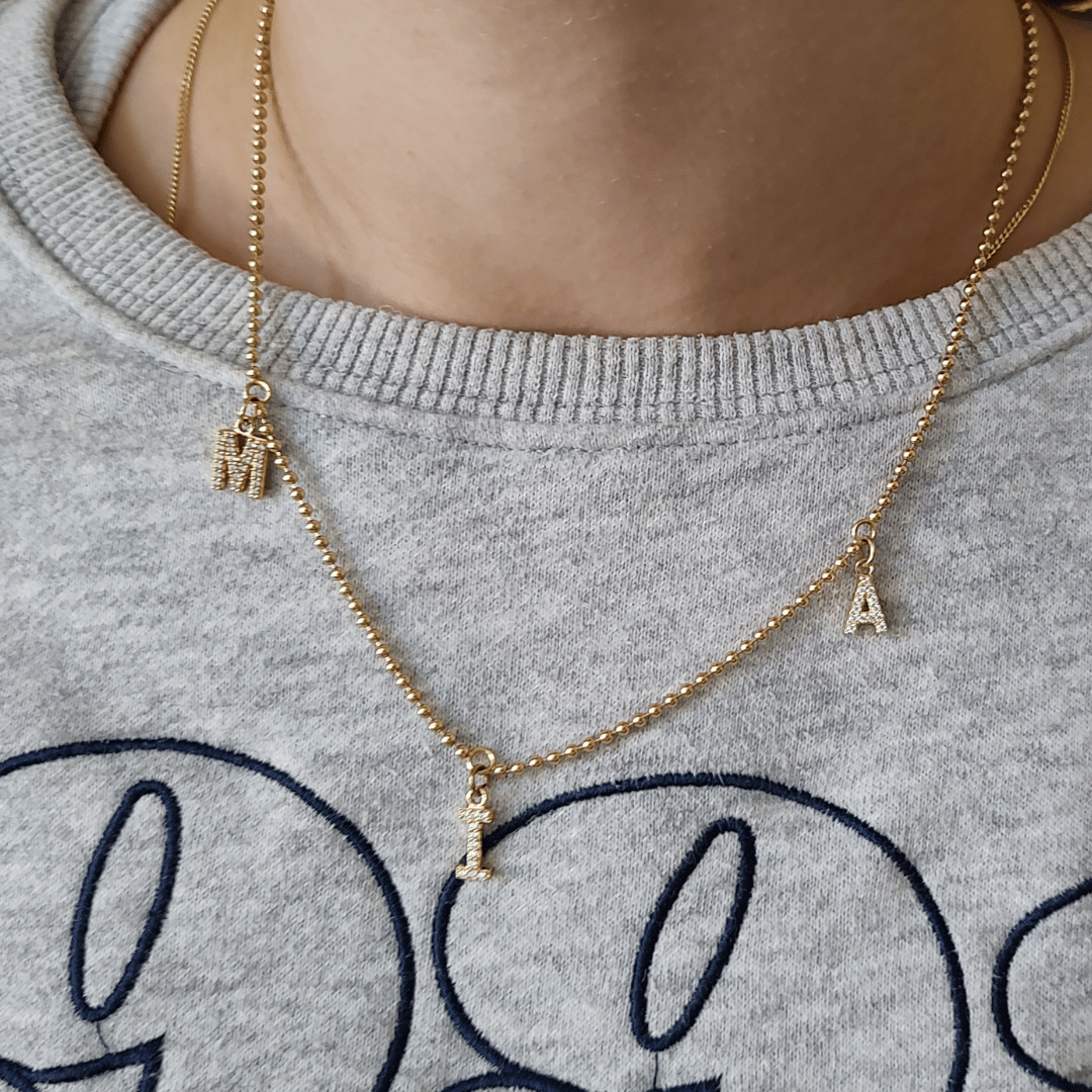Personalisierte Familienkette in Gold mit drei Buchstaben-Anhängern – die Initialen dreier geliebter Menschen an einer Kette vereint. Wunderschönes Geschenk für eine frischgebackene Mama zu geburt, um sich ihre Kinder zu verewigen. 