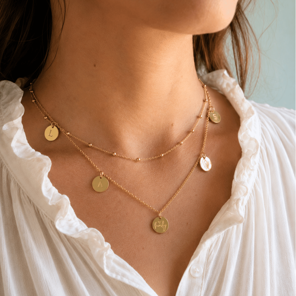 Die goldene Familienkette HAPPY FAMILY wird am Hals getragen, mit allen fünf Gravur-Anhängern deutlich sichtbar. Jeder Plättchen Anhänger kann individuell mit Namen, Initialen, Baby Fuss & Handabdrücken oder einem Geburtsdatum personalisiert werden. So trägt die Mama ihre Liebsten jeden Tag nah am Herzen.