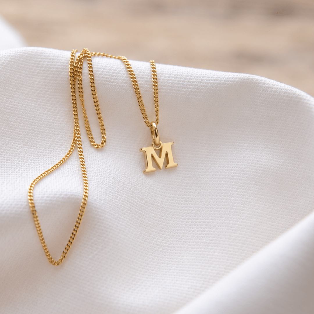 Zarte Initialenkette Gold mit dem Buchstaben-Anhänger M, individuell aus echtem Gold gefertigt in unserer Berliner Goldschmiede.