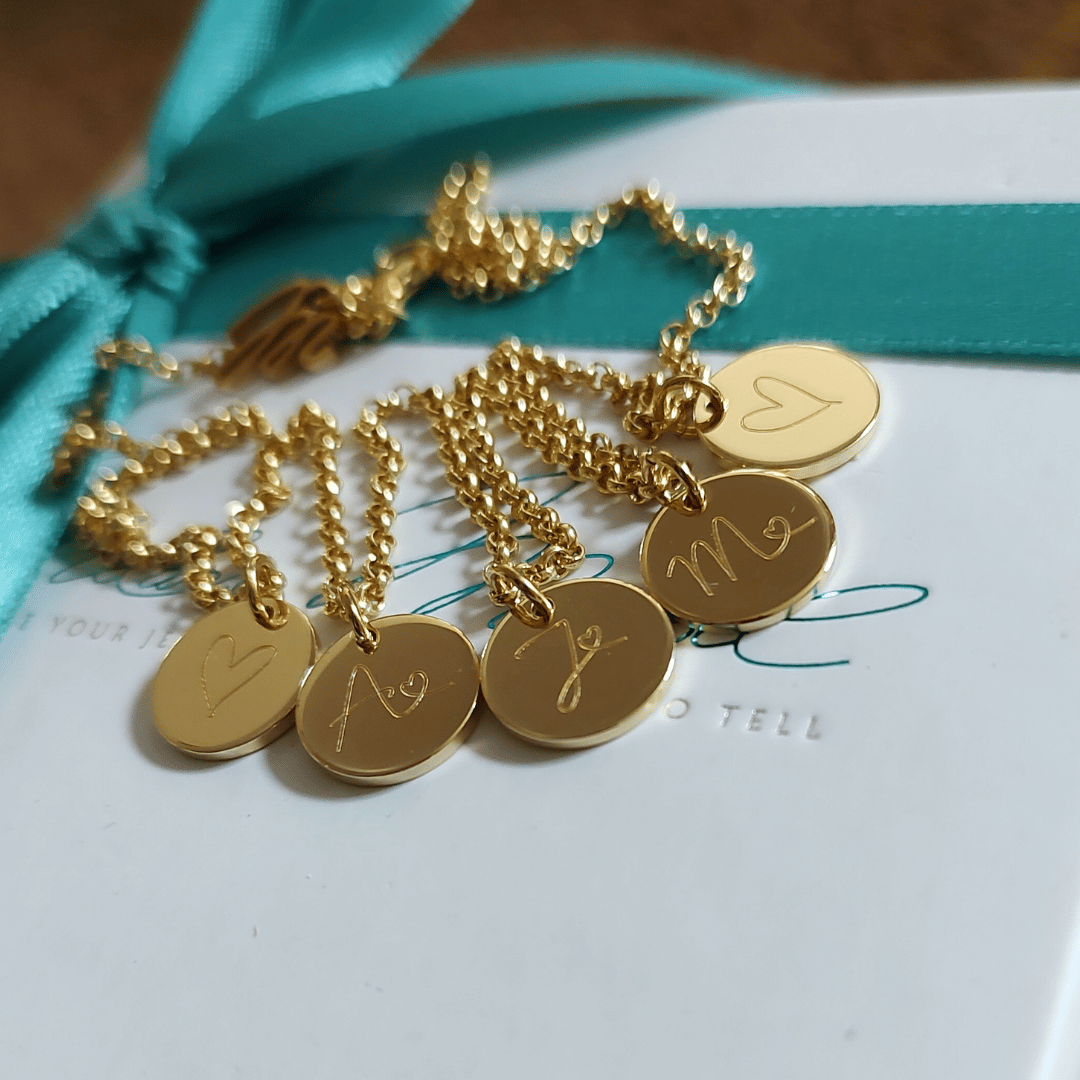 initialenkette personalisiert mit drei kleinen gravur Plättchen in der variante gold und jeder anhänger ist individuell nach kundenwunsch graviert mit den anfangsbuchstbaen der Kinder – ein liebevolles Geburtsgeschenk für Mama und auch ein geschenk von den enkelkindern für die oma zum geburtstag