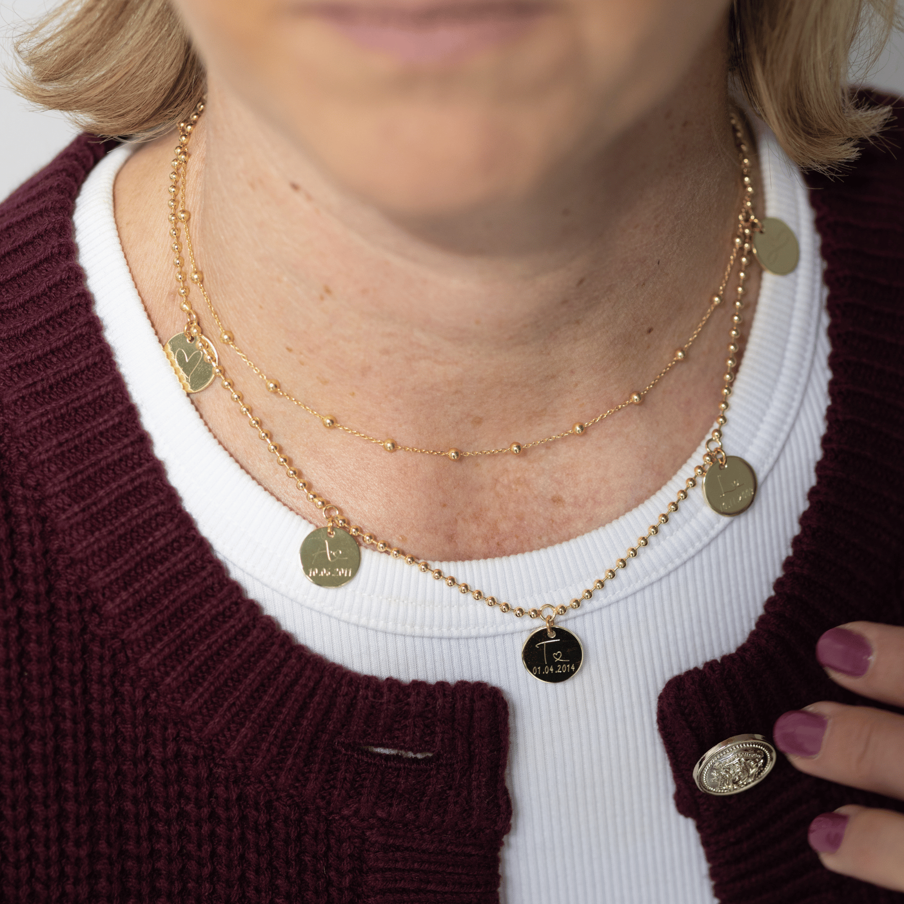 hochwertig verarbeitete Familienkette in Gold mit fünf Anhängern, graviert mit den Anfangsbuchstaben der Familie – ein Geschenk, das Zusammenhalt symbolisiert.