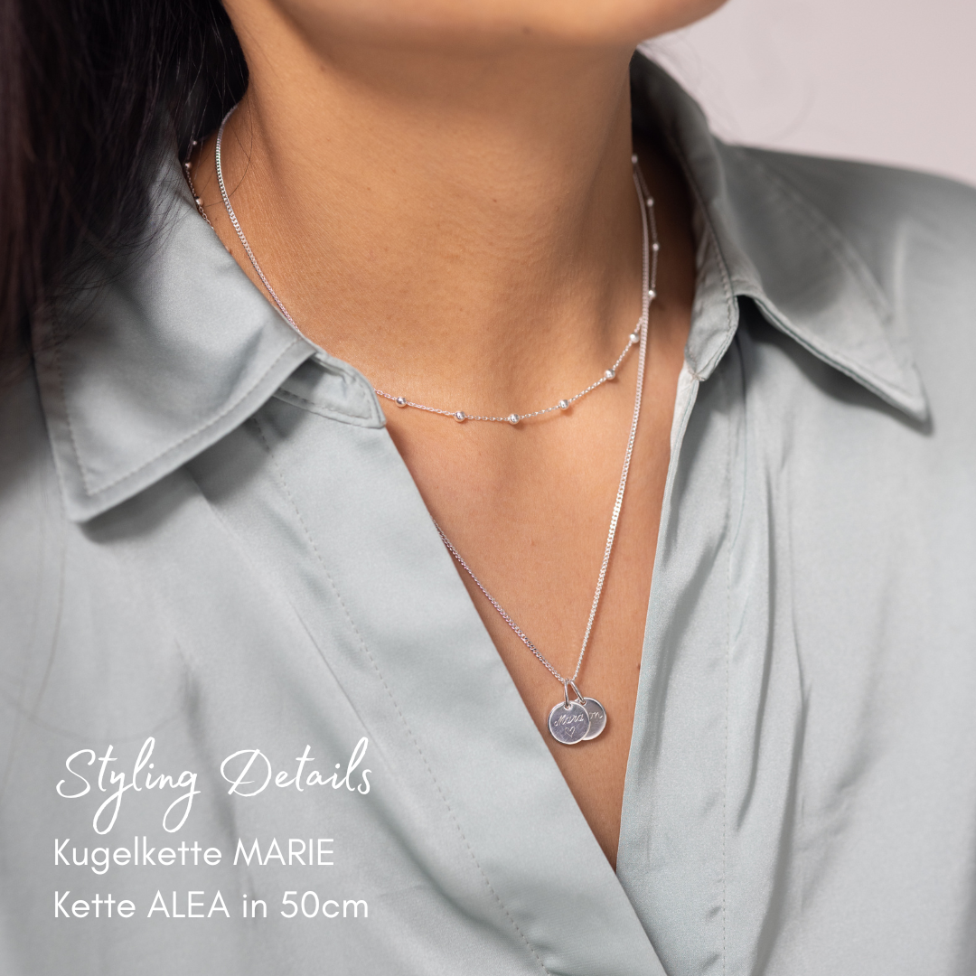 kette personalisiert mit 2 edlen Plättchen Anhänger, getragen am Hals einer Mama, die wir in unserem Berliner Atelier in Handarbeit fertigen und mit Kindernamen, Anfangsbuchstaben der Familie, Geburtsblumen oder Baby Fussabdrücken gravieren. 
