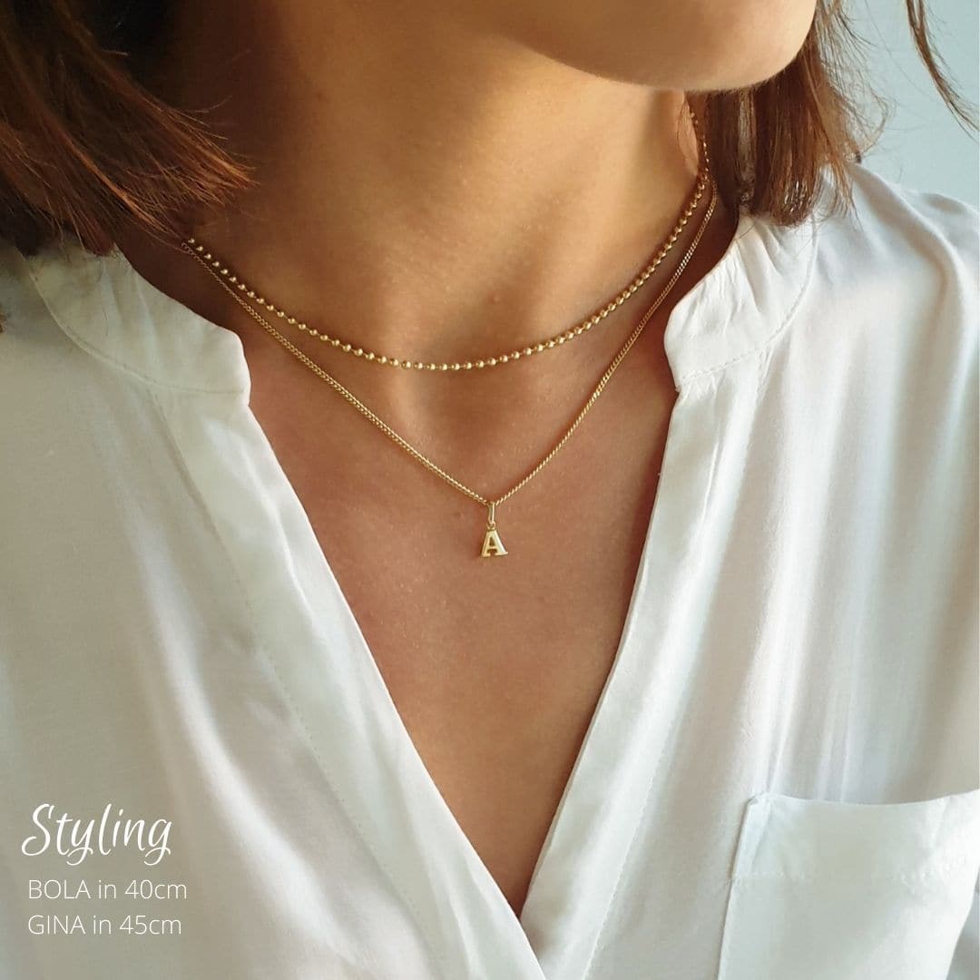echtgold Initialenkette mit Buchstaben-Anhänger A – individuell aus echtem Gold gefertigt in unserer Berliner Goldschmiede und elegant im layering look präsentiert