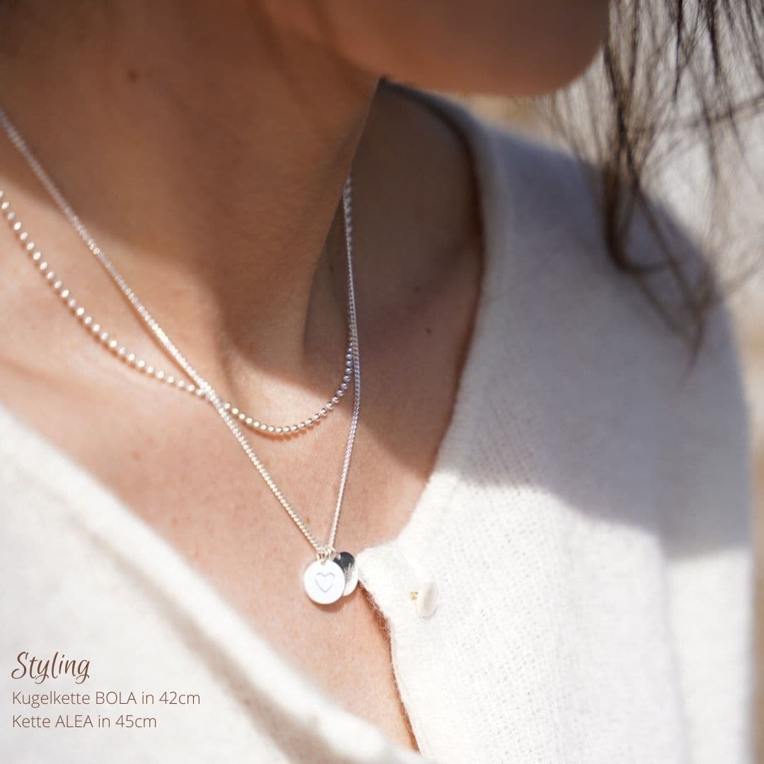 Personalisierte Kette am Hals getragen. Eine edle Initialen Kette mit Gravur für Mamas. Handgefertigt aus 925 Sterlingsilber in Berlin. Das perfekte Geschenk für Mütter zur Geburt oder um sich selbst etwas wertvolles und bedeutungsvolles zu schenken. 